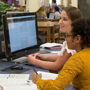 HSU students sitting at a computer studying in the library